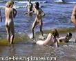 Family with 2 young girls and 2 young  playmates playing at nudist beach